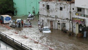 People are stranded in a flooded area in the Saudi Red Sea city of Jeddah on November 25, 2009. Saudi Arabia's civil defence said on November 26 that 77 people were killed in intense flooding after a downpour in Jeddah and nearby areas, and that scores could still be missing. Many of the dead were in automobiles and buses caught up in the rising waters, according to witnesses. AFP PHOTO/STR